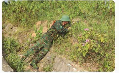 A person in camouflage climbing a hill

Description automatically generated