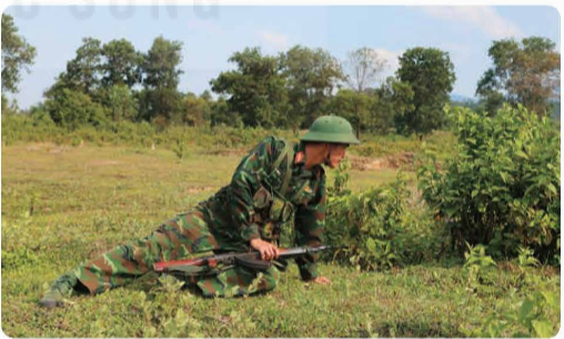 A soldier kneeling in the grass

Description automatically generated